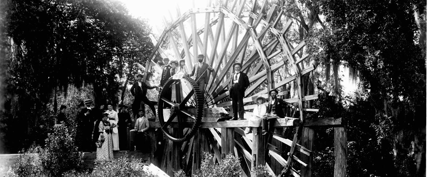 Black and White photo of people standing on the De Leon Springs sugar mill wheel