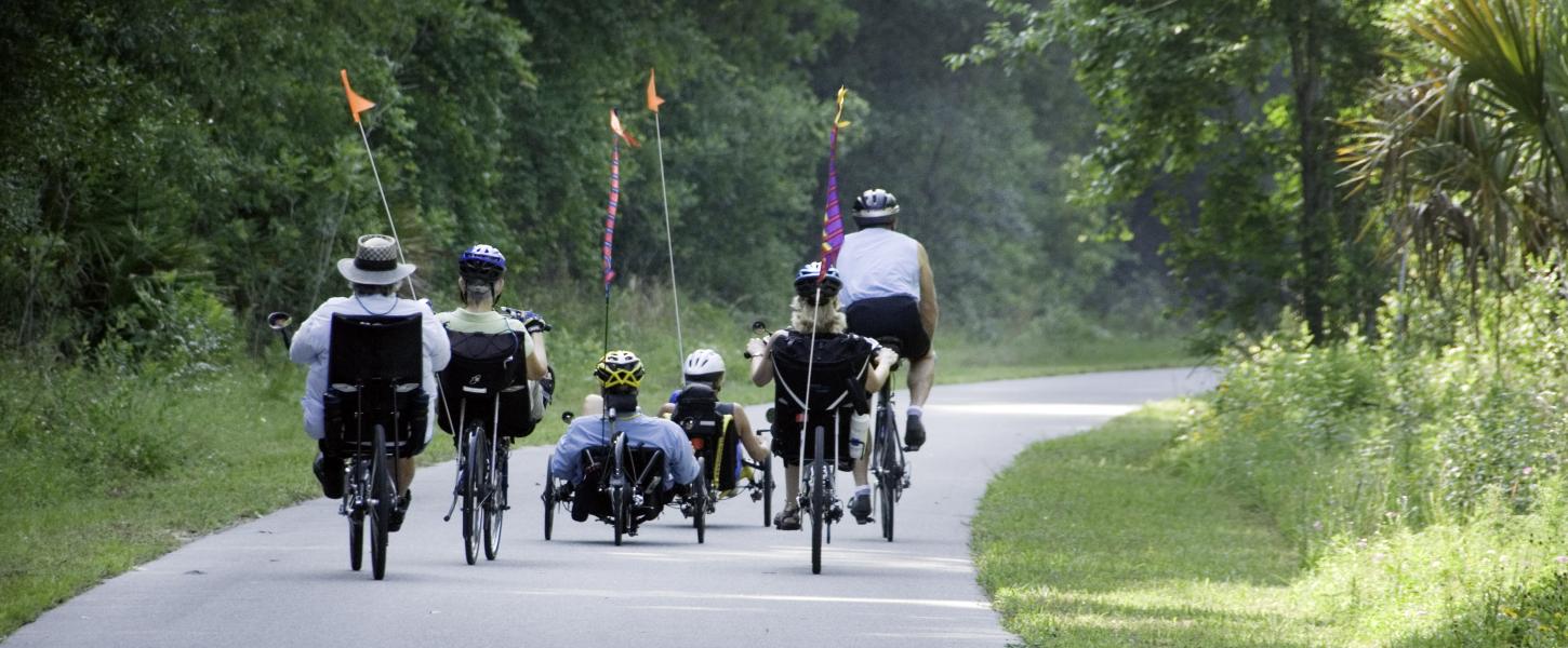 A group of bicycle riders on a paved trail. 