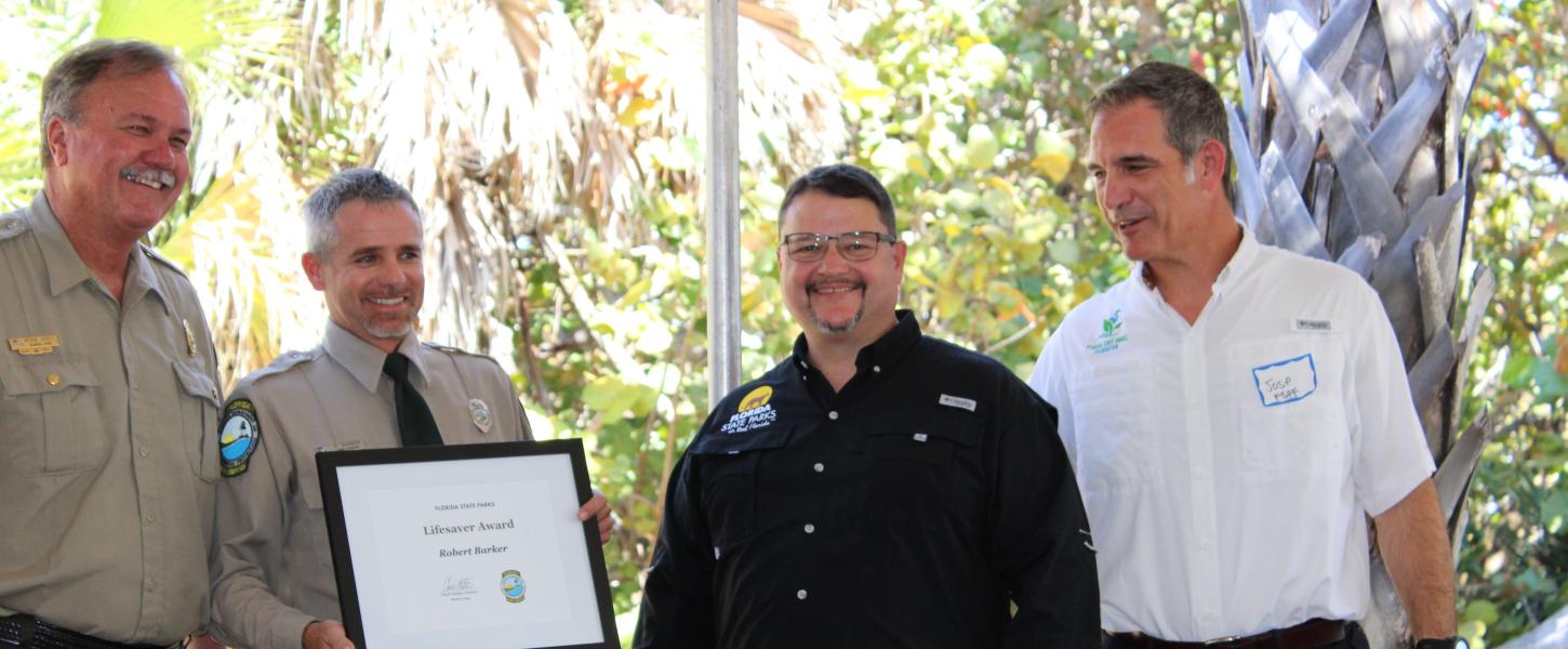 Paul Rice presents the award to Robert Barker with Brian Fugate and Jose Romano.