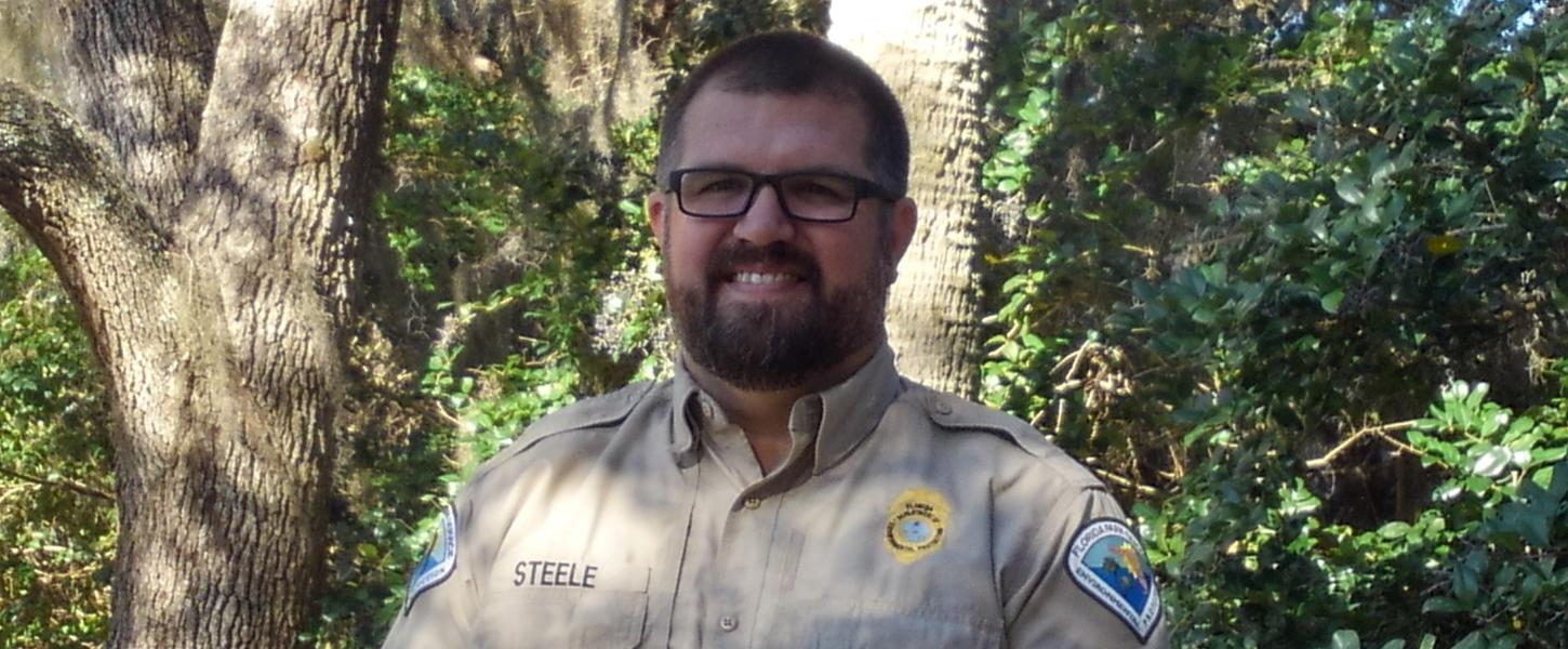 Park Manager Robert Steele stands under the shade of the trees.