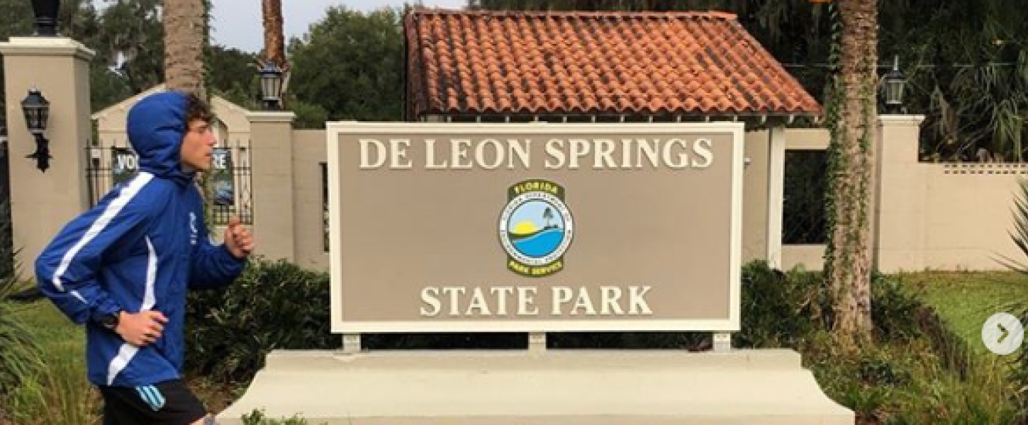 Charles Richardson runs past park sign at De Leon Springs State Park.