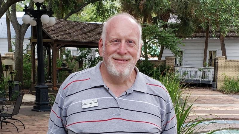 Curtis Brown smiling at the camera, standing in front of a nest of chicken eggs.