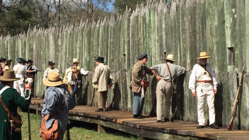 A view of reenactors lined up along the wall of the fort.