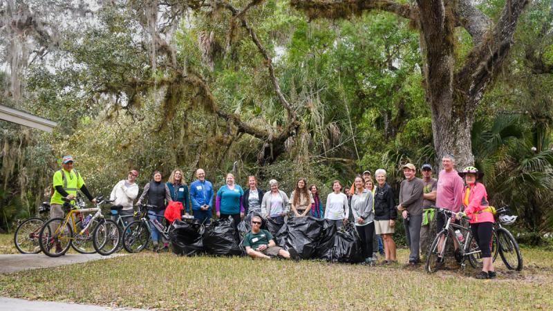 Volunteers pose for a photo under a tree,