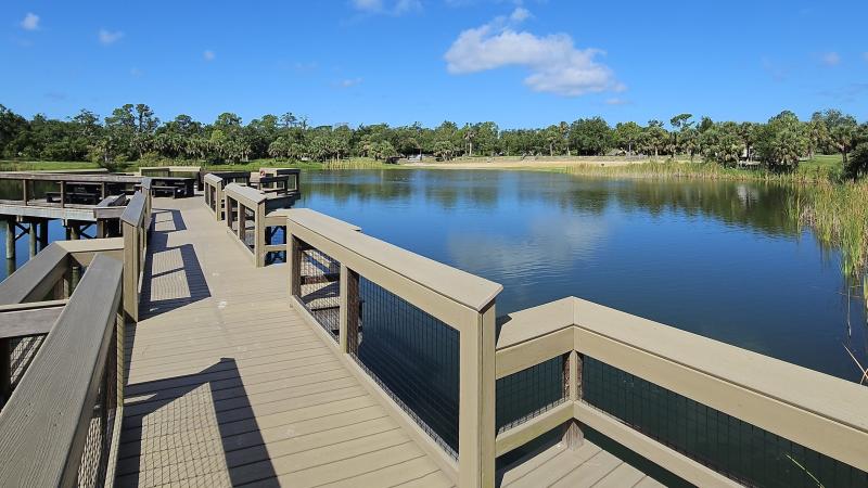 A wheelchair accessible fishing pier over a small lake. 