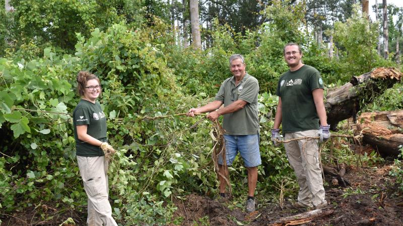 Volunteers take a quick breather to smile while working together at Three Rivers State Park.