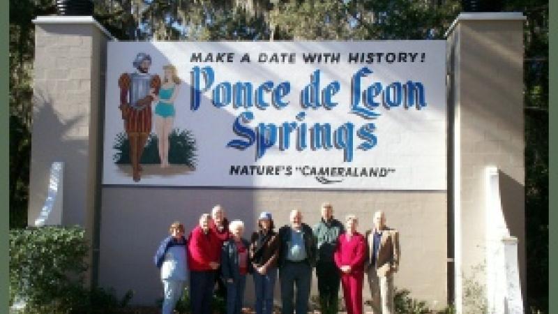 The Friends group standing in front of a banner,