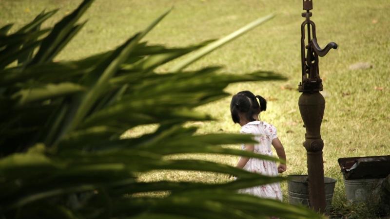 Little girl by the hand pump