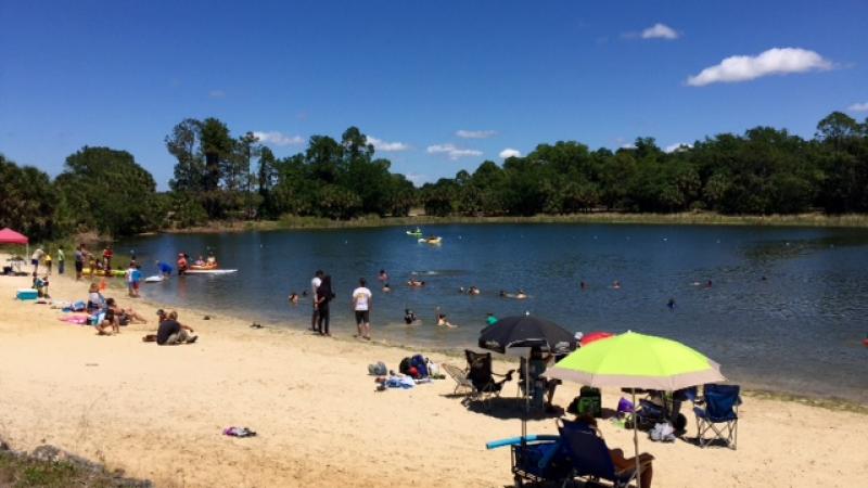 A view of Lake Osprey with people dotted along the shore.