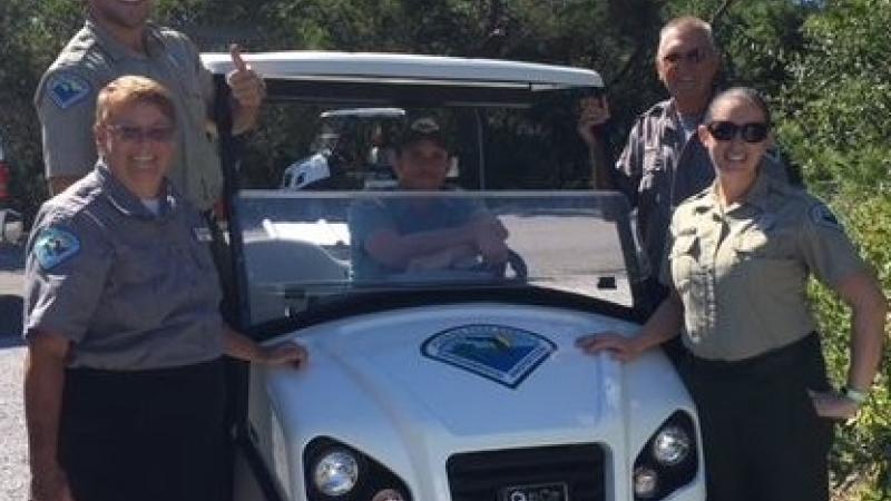 Members of the Friends group standing around a utility cart.