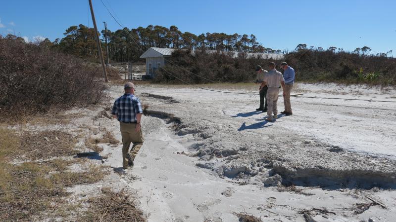 A view of some people walking along some of the damaged shoreline.