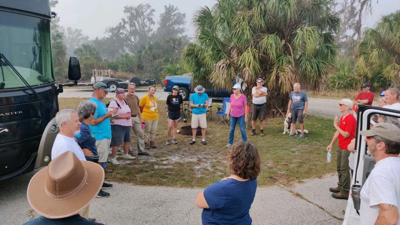 Volunteers gather around to learn about the next volunteer assignment.