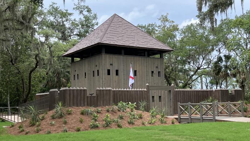 A small wooden fort with a palisade wall. 