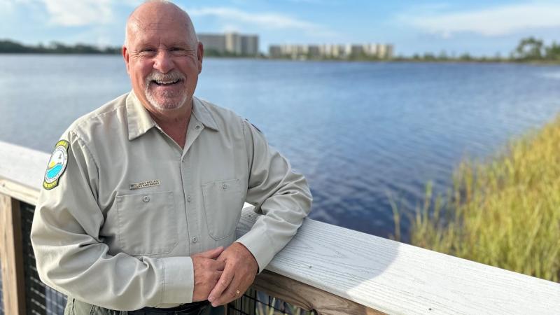 Jody standing on a boardwalk next to water