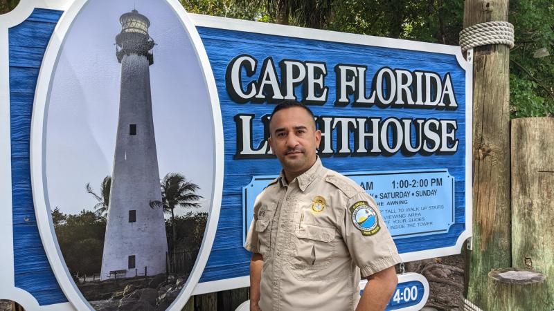 Jorge stands in front of the park sign.