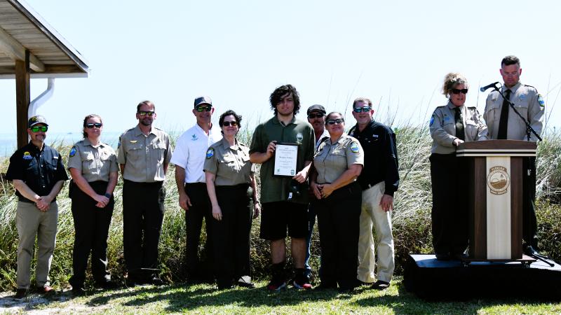 volunteer hold plaque award surrounded by park staff