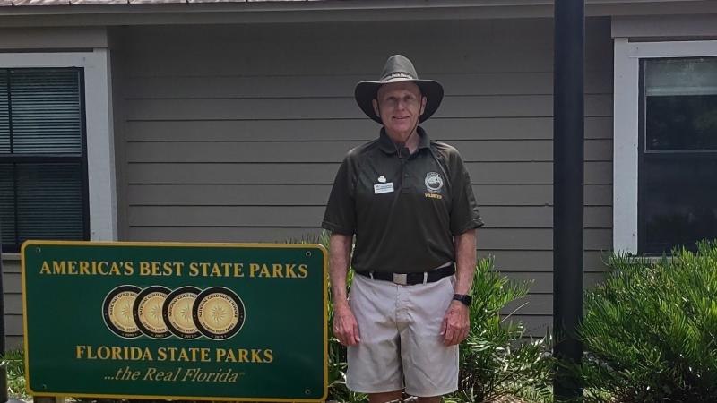 Ken McKinney standing next to a Florida State Parks sign.