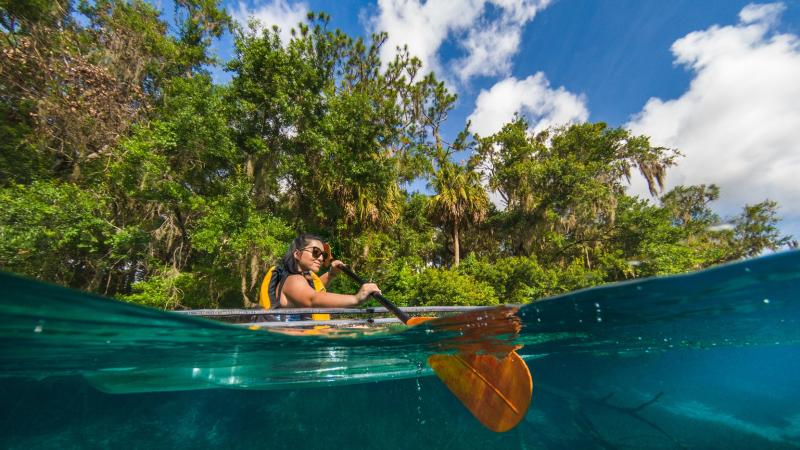 Paddler dips paddle into water at Rainbow Springs State Park 