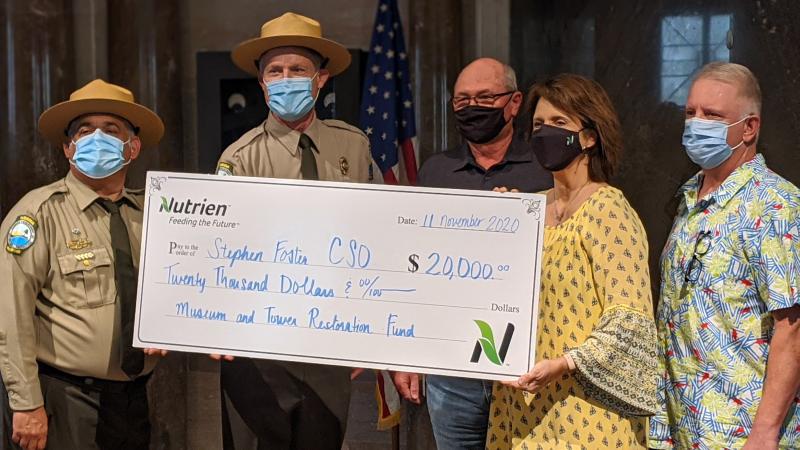 Employees of Nutrien present check to staff at Stephen Foster Folk Culture Center State Park.