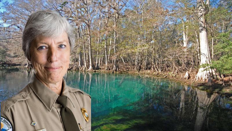 a park ranger in uniform in front of a blue spring