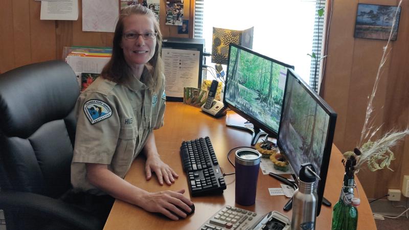 PSS Pam Hiler smiling at her work desk