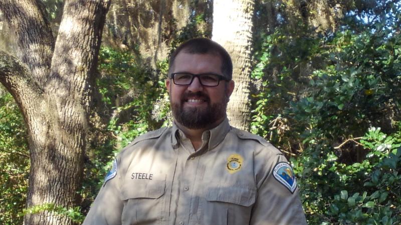 Park Manager Robert Steele stands under the shade of the trees. 
