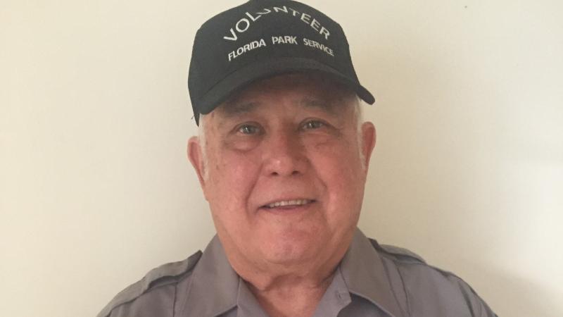 Sammy Alba, smiling at the camera, wearing his volunteer uniform.