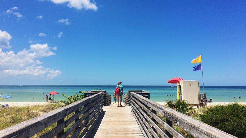 Giel walking toward the beach on a boardwalk