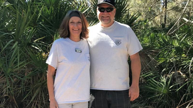 Rosie & Reggie smiling at the camera with saw palmetto in the background