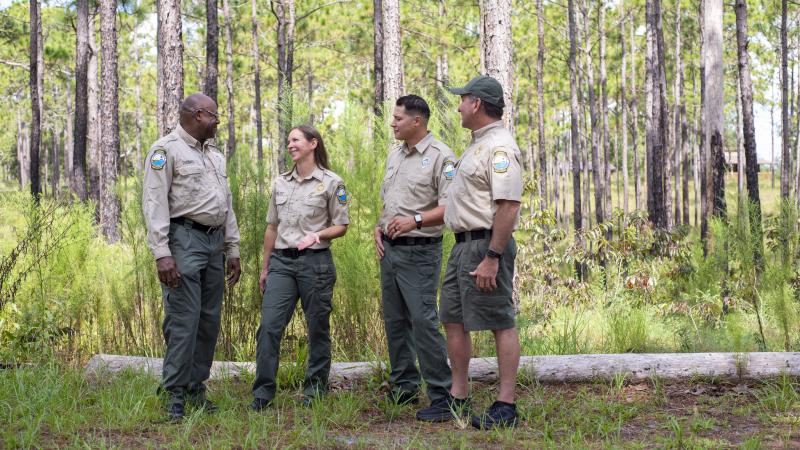 A group of rangers in uniform talking. 