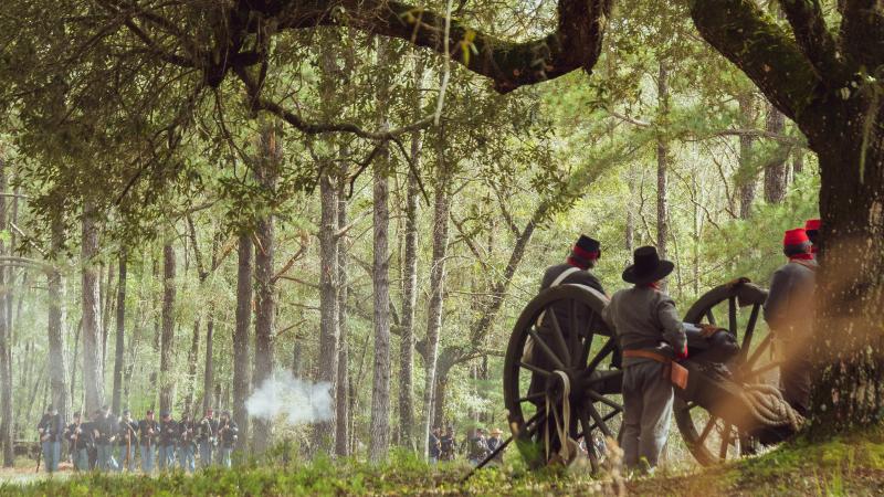 Reenactors fire cannon. 