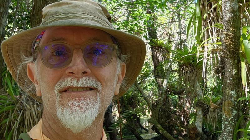 Dino Barrone smiling in front of a forest.