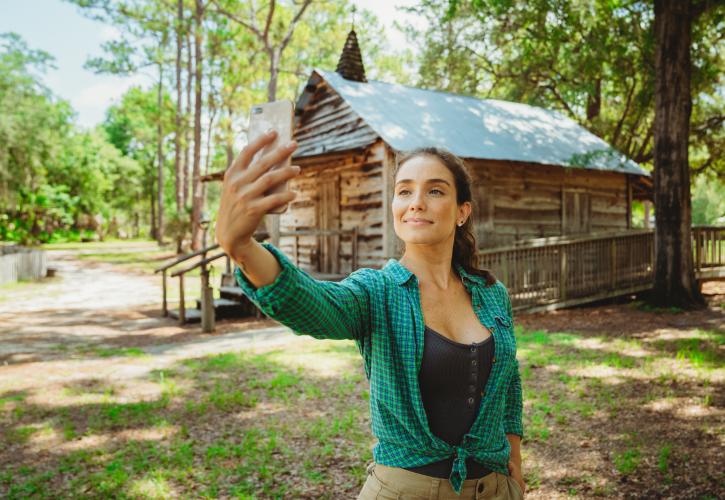 A woman takes a selfie at the Pioneer Village at Silver Springs State Park.
