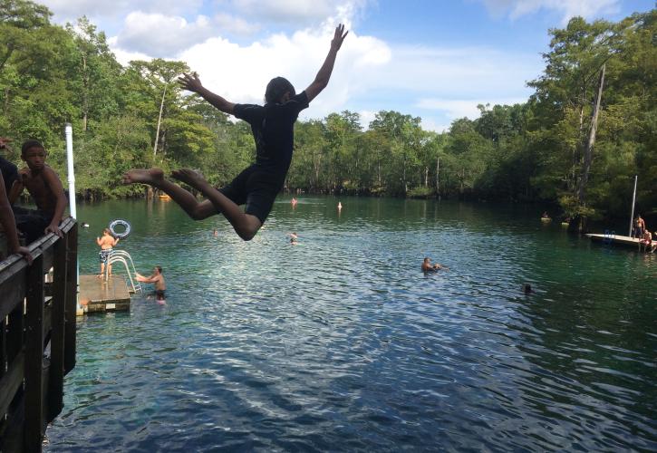 A boy jumping off the deck into the springs