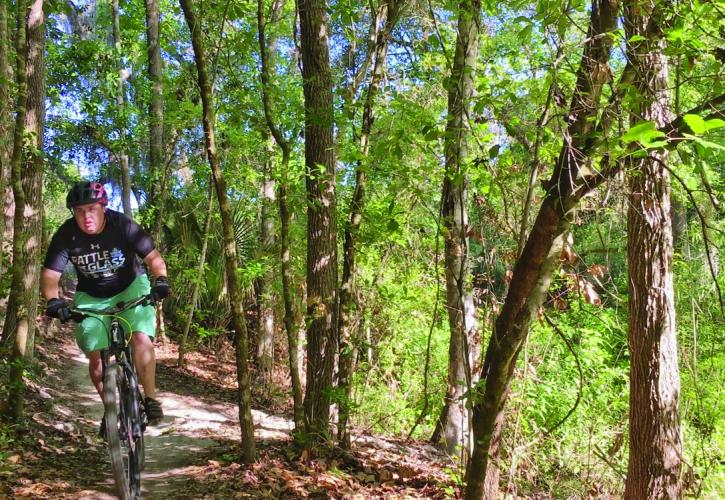 A man rides a trail at Alafia River State Park.