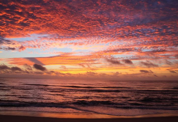 Pink and orange skies over the ocean during a sunrise at North Peninsula