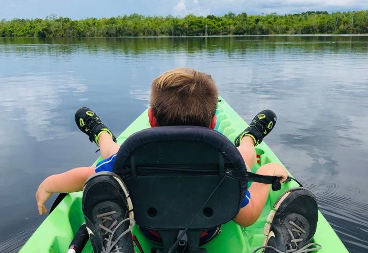 A child sits in the front of a kayak at Lake Griffin State Park.