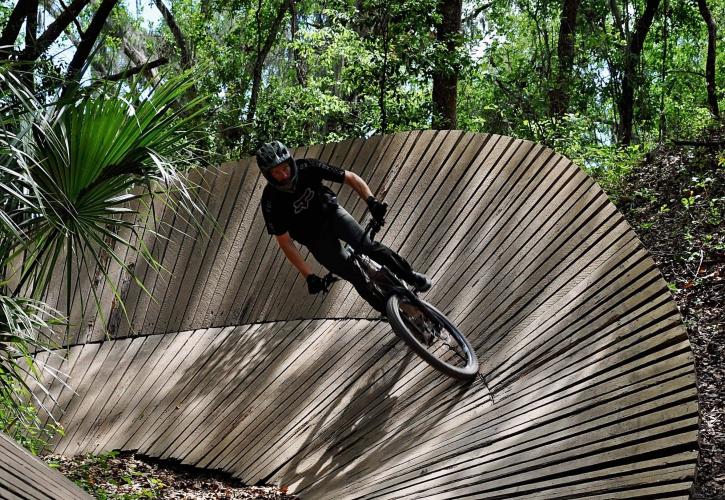 A mountain biker rounds the curve on a trail.