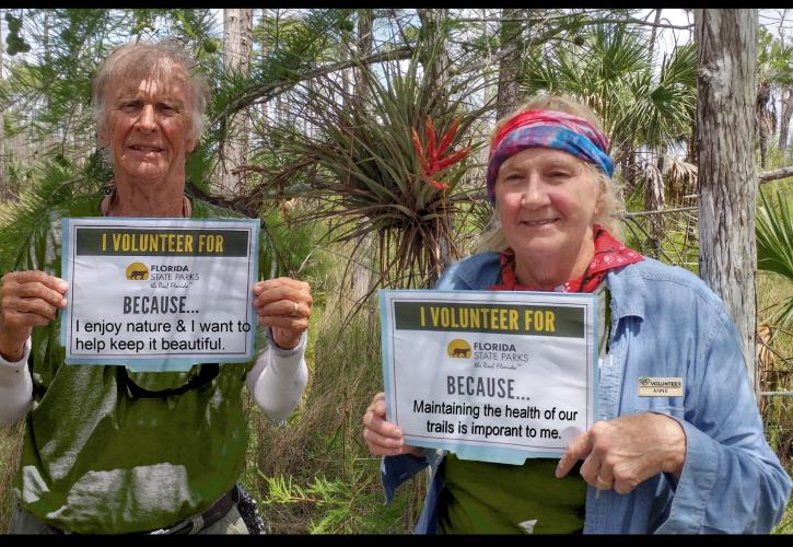 man and woman holding up signs