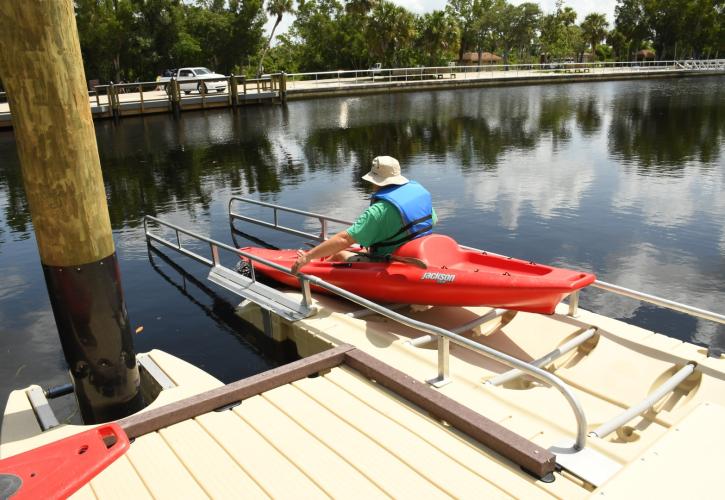 Man pushing off canoe launch in kayak into water