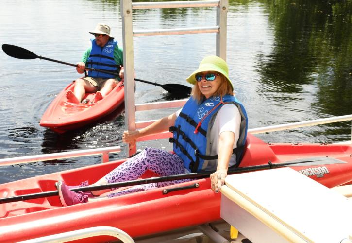 Woman sitting in a red kayak at canoe launch