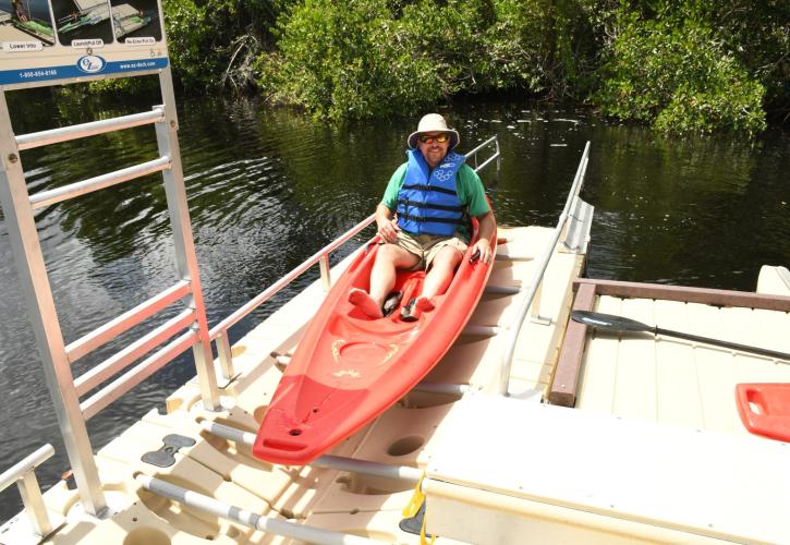 Man in a red kayak after entering canoe launch from water