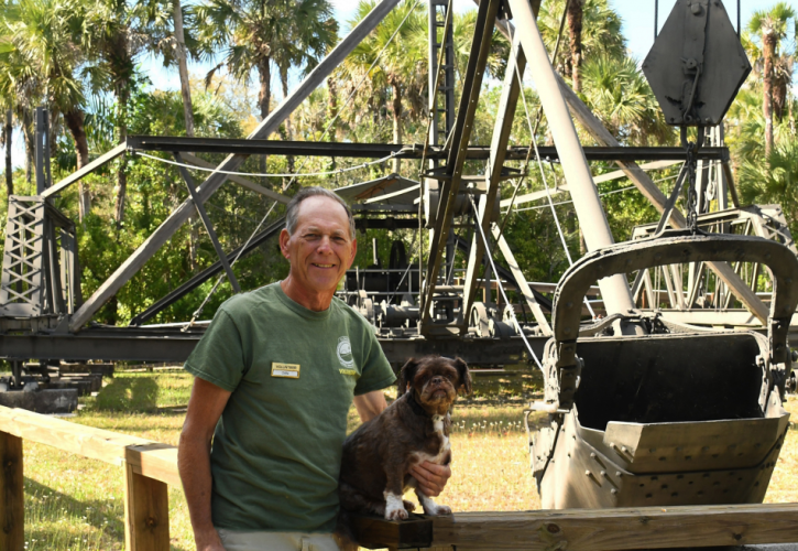 man posing at the Bay City Walking Dredge with his dog