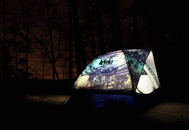 Tent is illuminated from inside surrounded by darkness. 
