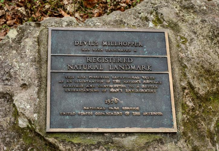 The plaque stating that Devil's Millhopper is a Natural National Landmark.