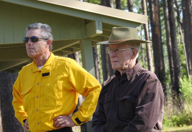 Eric Draper, director of the Florida Park Service, and Jim Stevenson, retired Chief Naturalist, listen while others speak before the commemorative prescribed fire on May 17, 2021, at Falling Waters State Park.