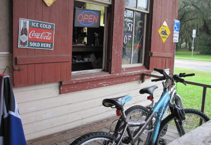 two bikes lean against a red wood storefront