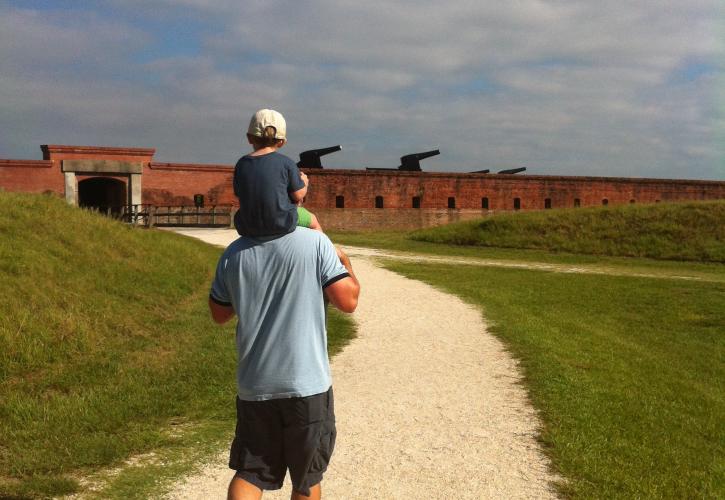 Visitor with child walking down fort path