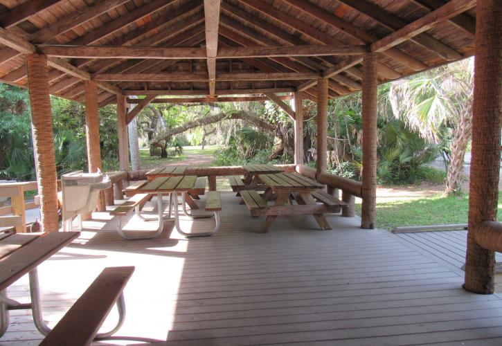 Benches and a water fountain under the wing of the Log Pavilion