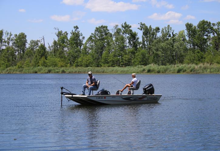 A view of a couple out on the lake fishing.